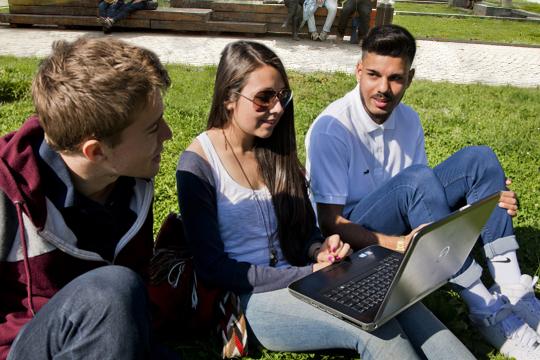 Groupe d'étudiants sur l'esplanade avec ordinateur